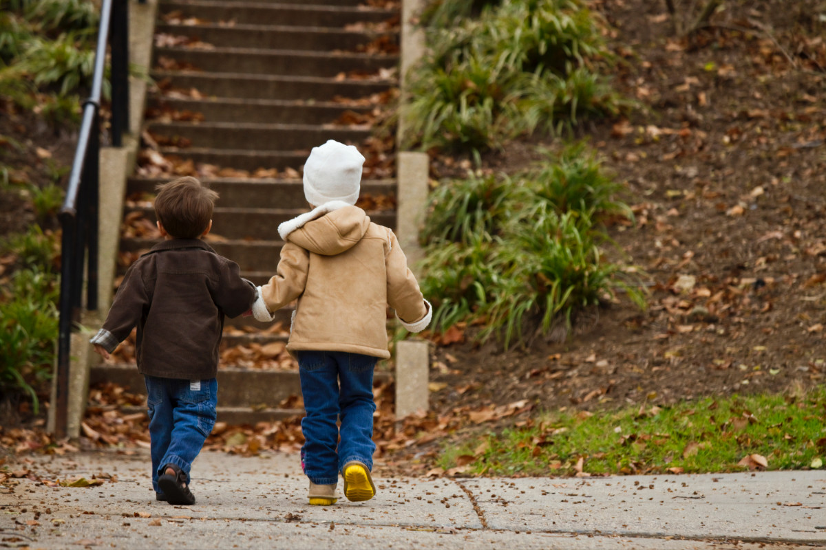 Due bambini che camminano tenendosi per mano